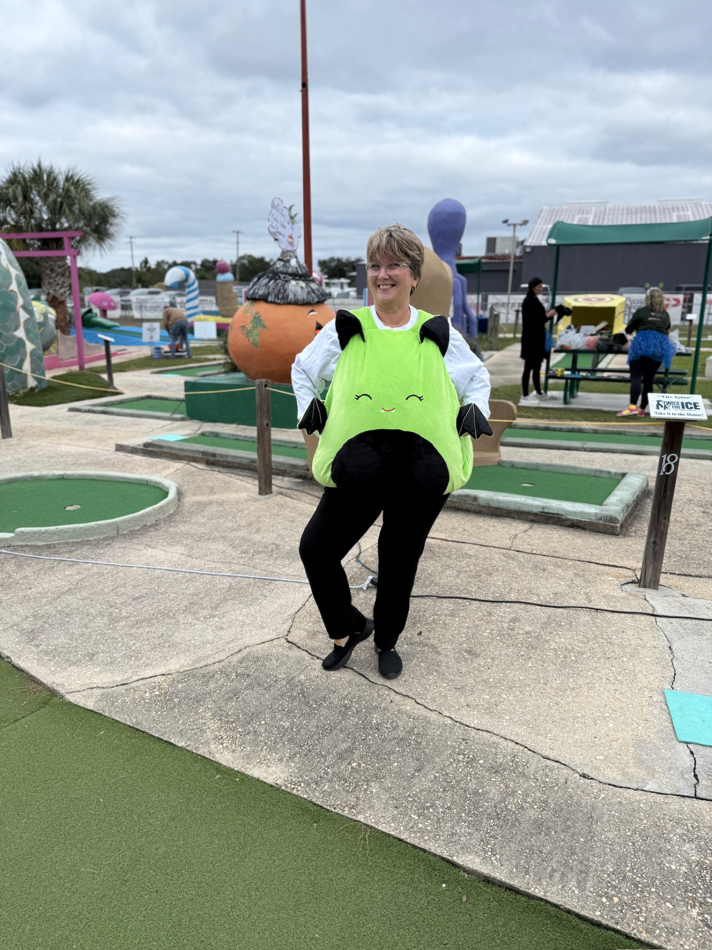 Player in a bat costume posing on the Goofy Golf course at a past Monster Mash