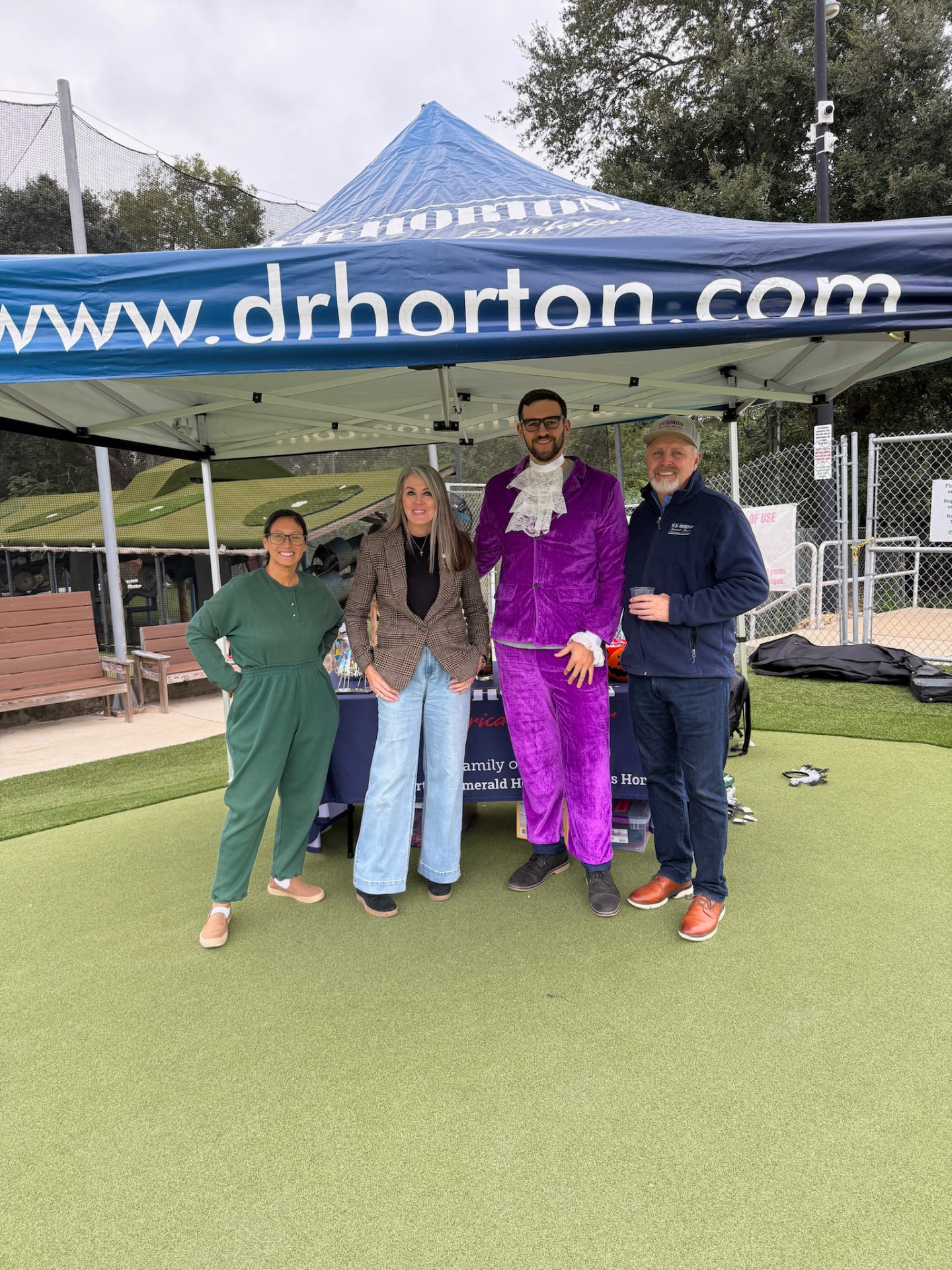 D.R. Horton sponsor tent crew, one in a purple velvet suit, on the green