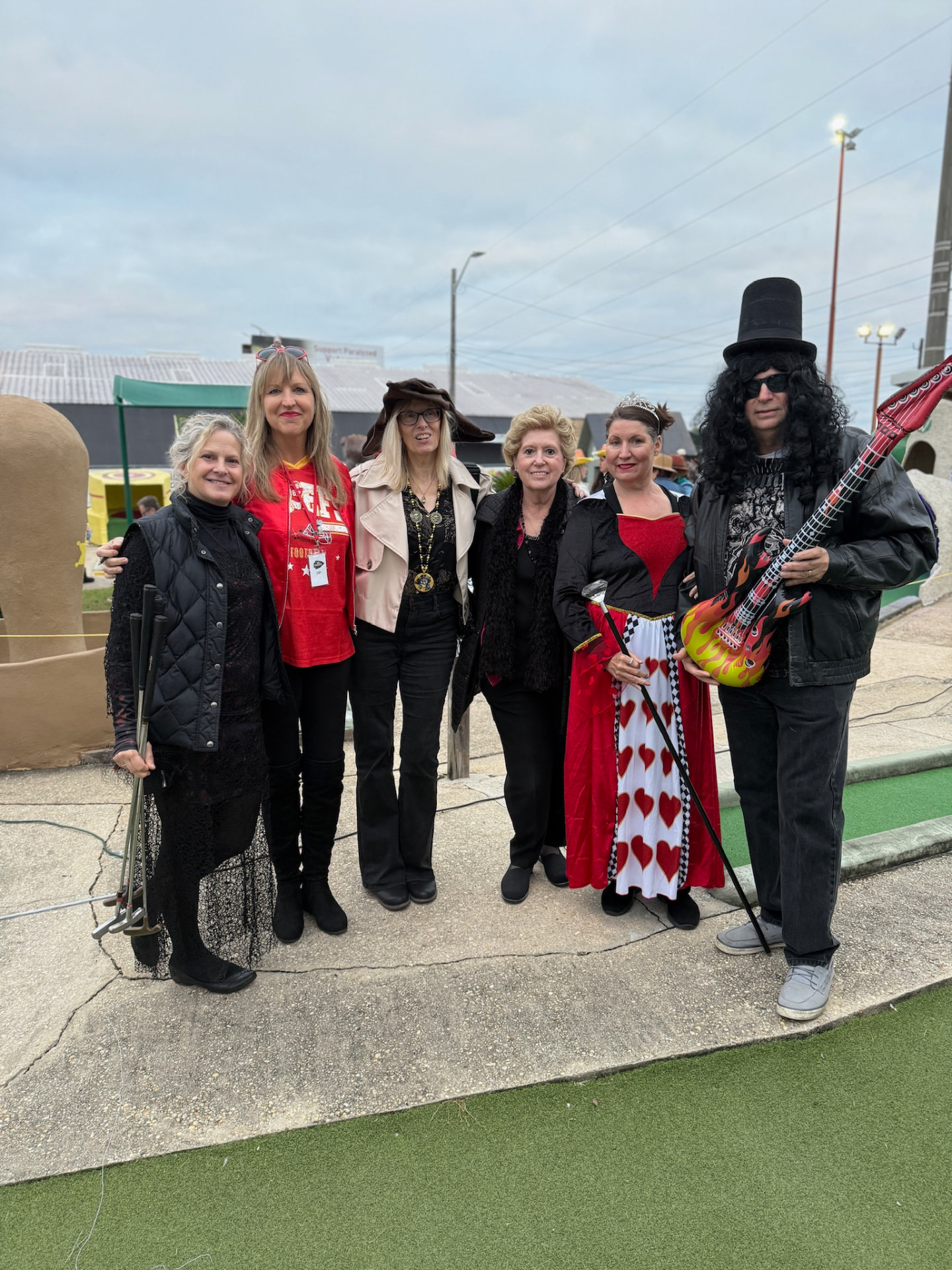 Group of guests in Halloween costumes holding putters on the course